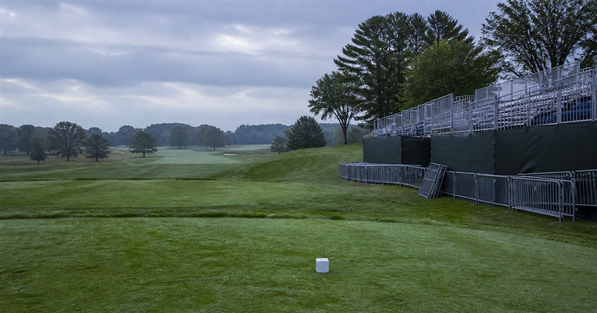 An empty championship tee beside partially dismantled spectator infrastructure